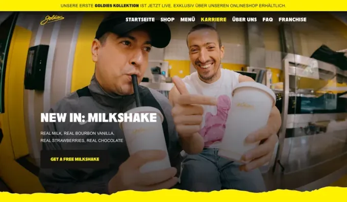 Webdesign-Referenz: Goldies — Hero mit Announcement-Bar und gerissener Gelb-Kante